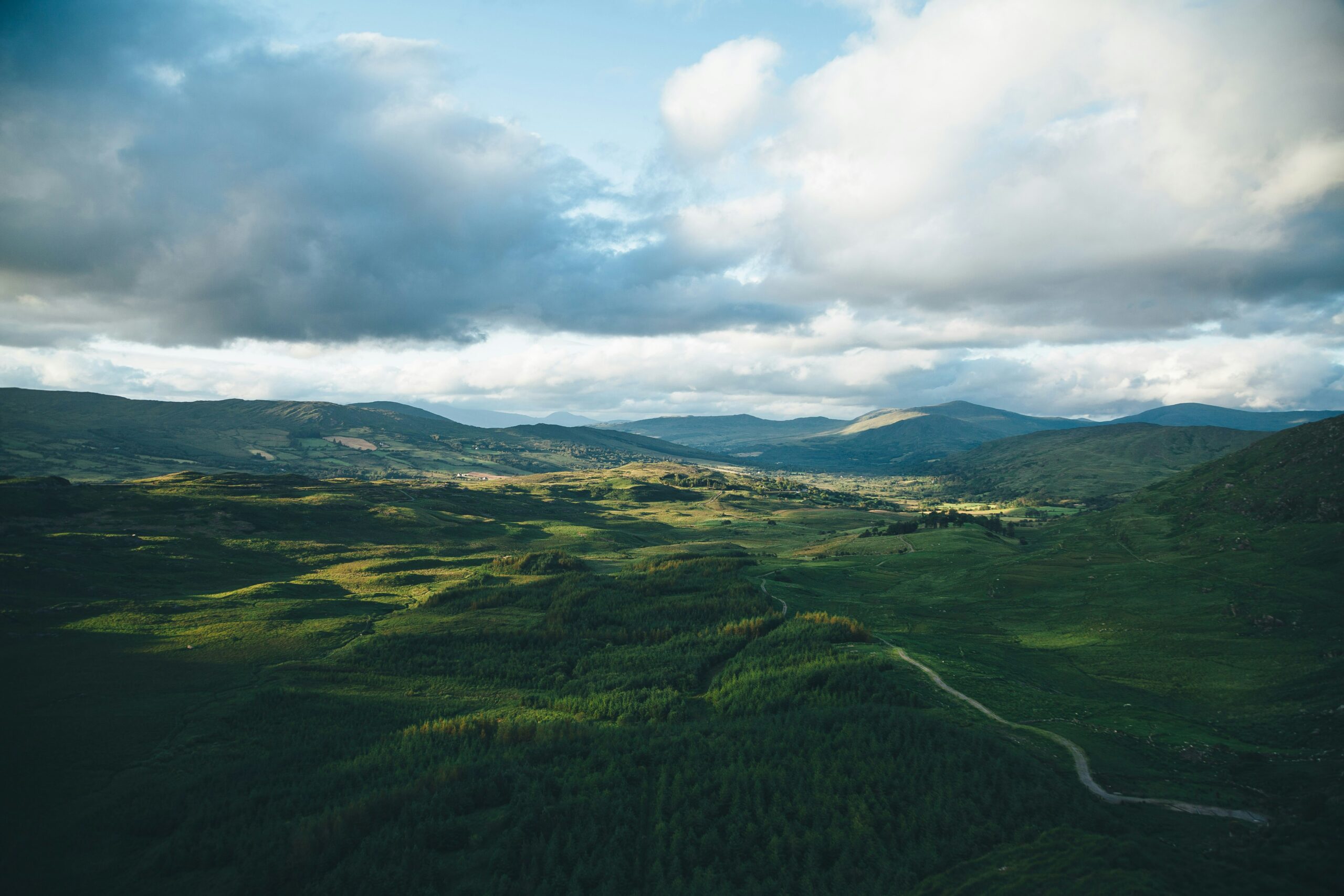 Vista of rolling Irish landscape with clouds above, shadows cast on the landscape below. Environmental social governance. Rewilding Ireland.